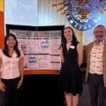 undergraduate students and professor at student research fair presenting a poster of their research